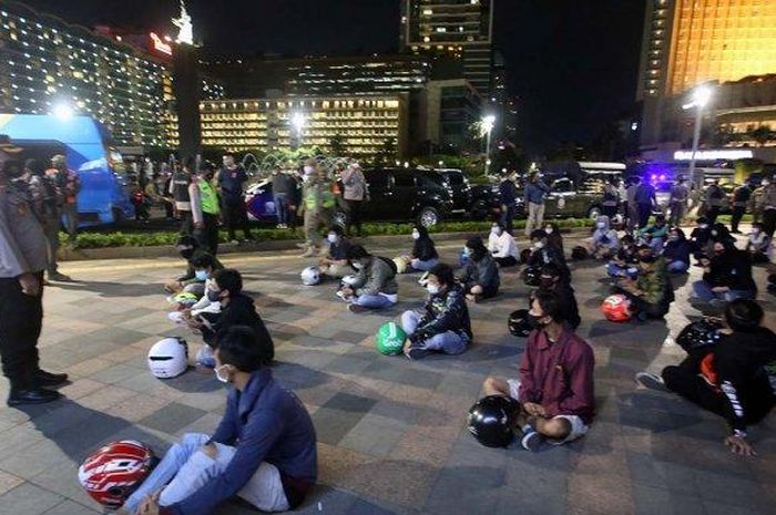 Satgas Pemburu Covid-19, mendata anak motor yang tertangkap berkerumun di Pos Polisi HI, Jakarta Pusat, Sabtu (26/12/2020) malam. (Wartakotalive.com/Angga Bhagya Nugraha)