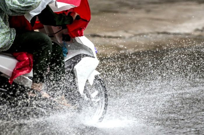 Ilustrasi berkendara motor saat hujan