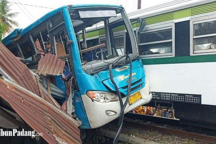 Tabrakan kereta api Vs bus Trans Padang di Lubuk Buaya Kota Padang. Bus terjepit antara badan kereta dan warung warga 