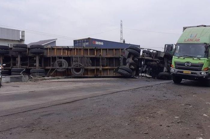 Truk kontainer yang terguling di Jalur Pantura di Desa/Kecamatan Patrol, Kabupaten Indramayu, Jumat (15/1/2021).  