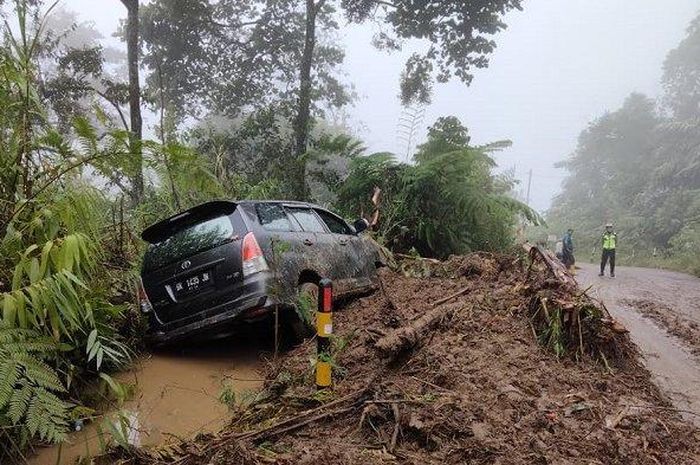Kijang Innova terperosok ke parit dikarenakan tergelincir saat melewati tanah longsor
