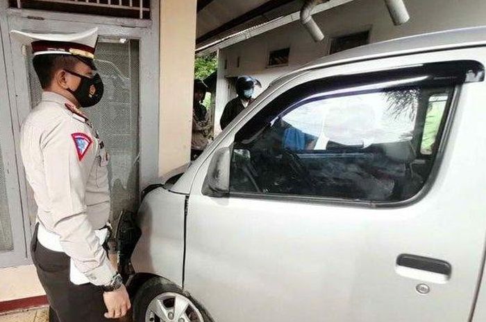 Petugas memeriksa mobil Gran Max B 1855 NKI yang menabrak sepeda motor lalu berhenti setelah menabrak tembok rumah, Selasa (19/1/2021). 