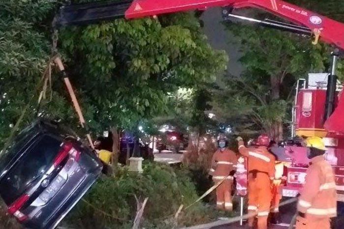 Toyota Calya dikail petugas pemadam kebakaran dari dalam sungai di Jl A. Yani, kota Surabaya, Jawa Timur