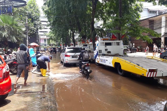 Ilustrasi kendaraan towing yang ingin mengangkut kendaraan yang terendam banjir
