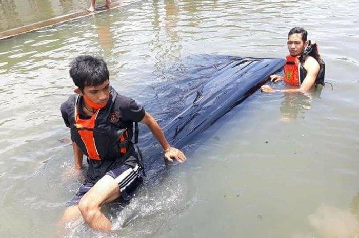Mobil Gran Max warna hitam asal Tuban kecebur sungai Gebanganom lantaran sopir tak waspada saat jalan direndam banjir, di Kota Semarang, Jumat (26/2/2021). 