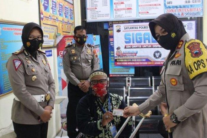 Kapolres Tegal Kota AKBP Rita Wulandari Wibowo (kanan) menyerahkan SIM D gratis bagi disabilitas fisik, Senin (08/03/2021) .