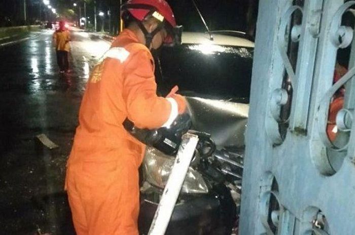 Personel Damkar Jakarta Timur saat proses evakuasi mobil Nissan Livina berpelat B 1839 BFF yang menabrak pagar TMII di Cipayung, Selasa (9/3/2021)  