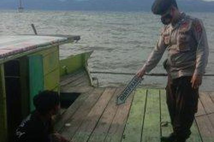 Polisi olah TKP di atas perahu kayu yang menjadi lokasi Toyota Hilux dinas PU Sulawesi Selatan tenggelan di Danau Matano, Nuha, Luwu Timur, Sulsel, (11/3/21)
