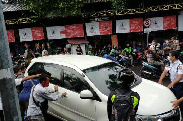 Warga inisiatif dorong mobil yang parkir di atas rel di depan Beteng Trade Center (BTC) Solo, Kamis(11/4/2021).  