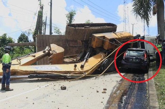 Daihatsu Sirion terjepit eskavator ambruk dari atas truk habis napas di tanjakan Tenggarong Seberang, Kutai Kartanegara, Kalimantan Timur