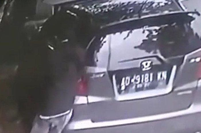 Rekaman CCTV saat kaca pintu belakang kiri Honda Jazz digetok pria yang menggasak laptop dan HP di dalam kabin