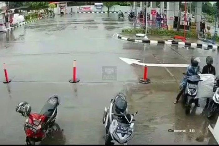 Tangkapan layar dua orang menggondol satu karung paket milik kurir yang sedang terparkir di SPBU Jalan KH Hasyim Ashari, Kamis (25/3/2021). 