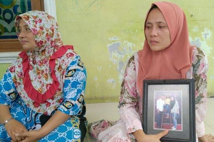 Yulia, istri almarhum Ridho yang menjadi korban penembakan misterius, memegang foto keluarganya saat ditemui di rumah duka, Jalan Yos Sudarso KM 14,5 Simpang Darmin Gang Keluarga, Medan Martubung, Kota Medan, Senin (29/3/2021). (TRIBUN MEDAN / M FADLI TARADIFA)