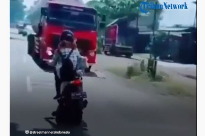 Seorang pemotor wanita ugal-ugalan di jalan raya, hampir adu banteng dengan truk
