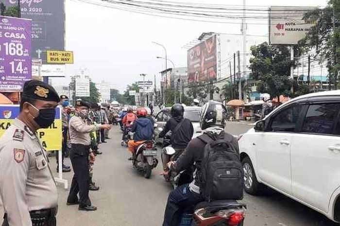 Petugas gabungan mslakukan pengawasan di lokasi penyekatan larangan mudik di Jalan Sultan Agung, Kecamatan Medan Satria, Kota Bekasi, pada Selasa (28/4/2020). 