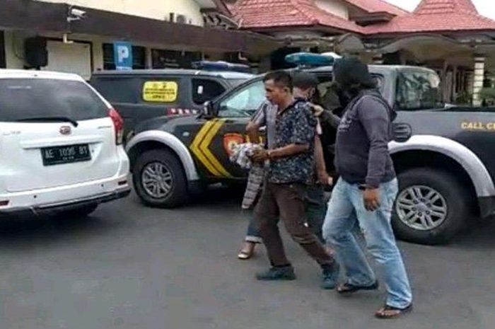 Petugas Polres Madiun membawa pelaku pencurian uang dari mobil boks Alfamart di Madiun, Rabu (28/4/2021).