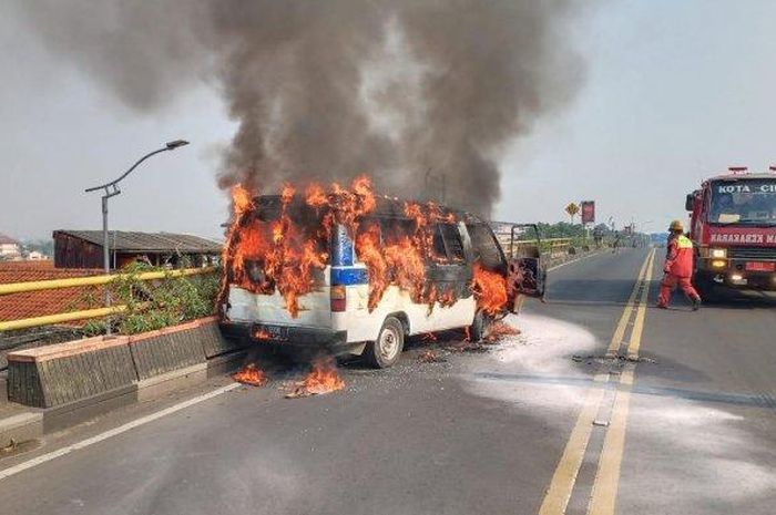 Satu unit kendaraan roda empat yang disinyalir angkutan karyawan pabrik terbakar di Flyover Cimindi, Kota Cimahi, Jumat (30/4/2021). 