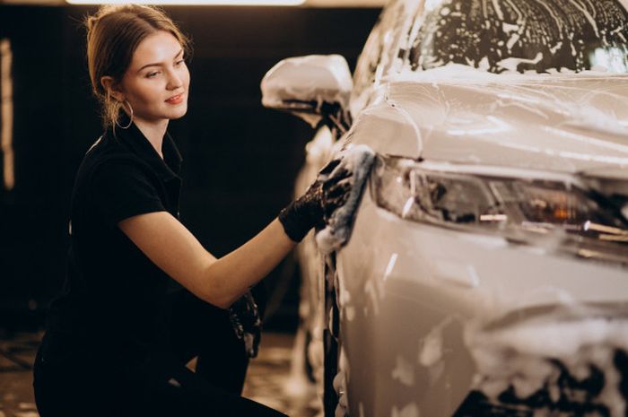 Ilustrasi seorang perempuan mencuci mobil.