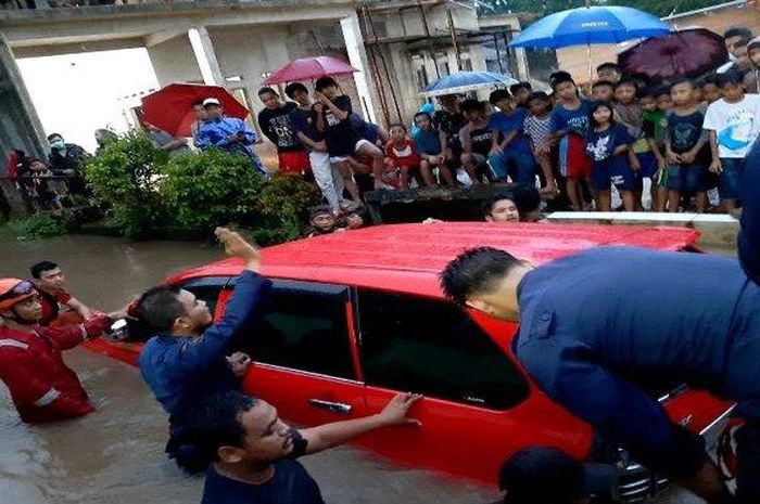 Toyota Avanza terjungkal ke dalam sungai saat banjir di Bojongsari, Depok, Jawa Barat