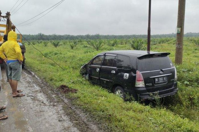 Toyota Kijang Innova masuk selokan karena terpeleset jalan licin di Jalan Lintas Sumatera, desa Sei Beluru, Meranti, Asahan, Sumatera Utara