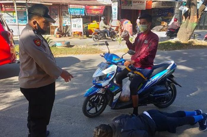 Petugas dari jajaran Polsek Tamalanrea, Makassar, Sulawesi Selatan menghukum pengendara yang abai prokes