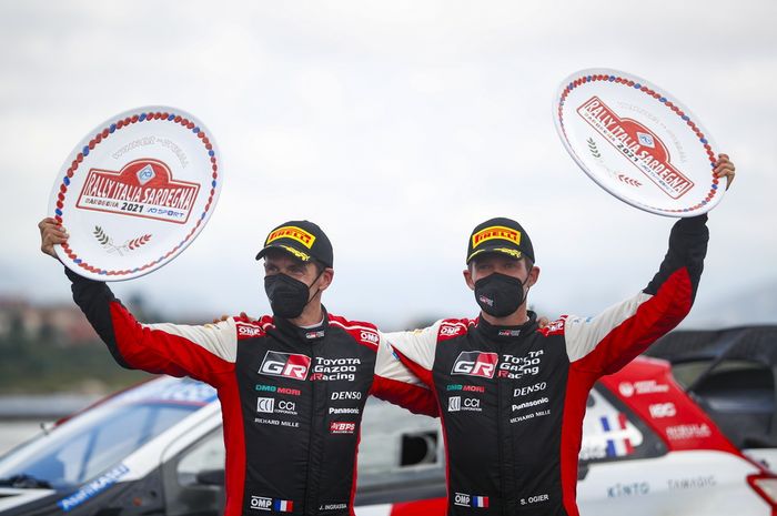 Pereli tim Toyota, Sebastien Ogier (kiri) dan co-driver Julien Ingrassia mengangkat trofi kemenangan di Reli Italia 2021