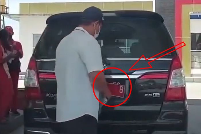 Momen saat pengemudi Toyota Kijang Innova berpelat dinas menganti jadi pelat hitam.