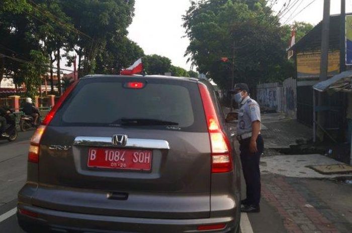 Honda CR-V pelat merah B 1084 SQH yang memasang bendera Indonesia namun terbalik menjadi putih merah