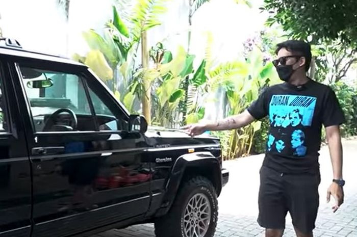 Deddy Mahendra Desta berpose di samping Jeep Cheroke