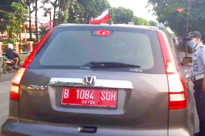 Anggota Dishub Jaksel menghentikan Sebuah Mobil Honda CR-V berpelat nomor merah di Jalan Ciputat Raya, Kebayoran Lama, Jakarta Selatan pada Rabu (25/8/2021). Mobil itu dihentikan karena memasang bendera merah putih terbalik. 
