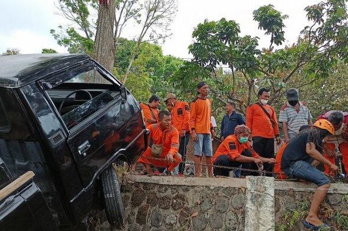 Para relawan beramai-ramai menarik Mitsubishi L300 yang terperosok di kebun sedalam 2,5 meter dari badan jalan di desa Salam, Karangpandan, Kabupaten Karanganyar, Jateng