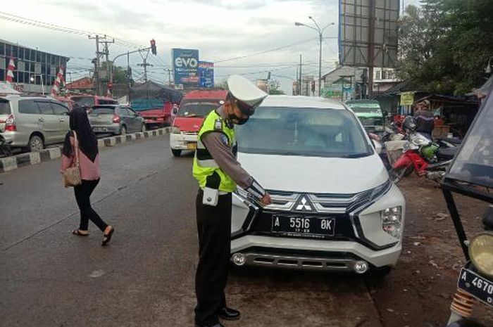 Mitsubishi Xpander dihentikan oleh petugas di dekat perempatan Ciruas, Kabupaten Serang, Banten pada Rabu (15/09/2021).