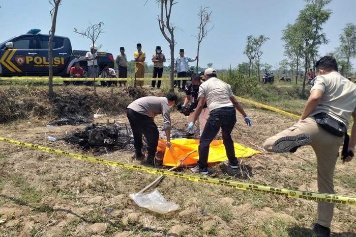 Polisi mengevakuasi jasad pengendara motor yang dibakar hingga tewas karena dituduh mencuri motor tanpa bukti di Kwanyar, Bangkalan, Jawa Timur