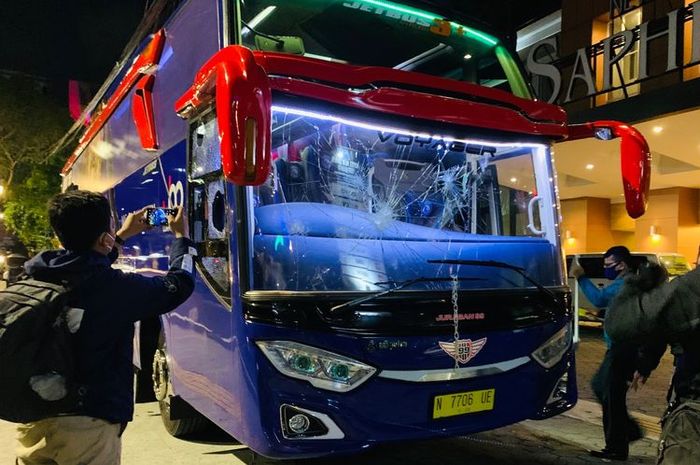 Seorang pria mendokumentasikan bus Arema FC yang baru saja diserang segerombolan orang tidak dikenal di depan Hotel New Saphir Yogyakarta, Rabu (20/10/2021) malam. (KOMPAS.com/Suci Rahayu) 