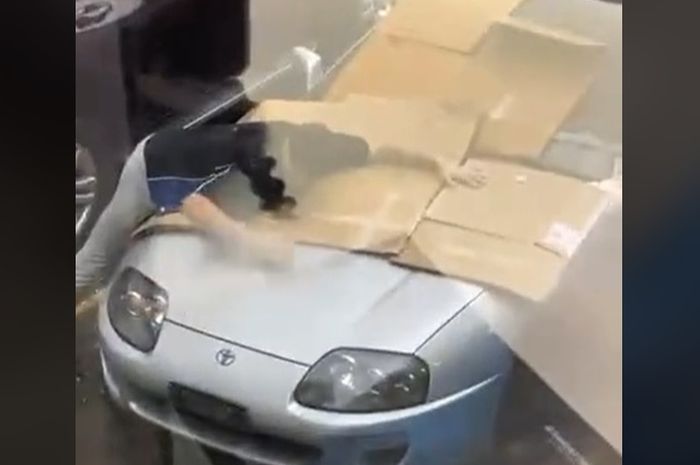 Seorang pria rela menjadi tameng untuk Toyota Supra MK4 dari hujan es