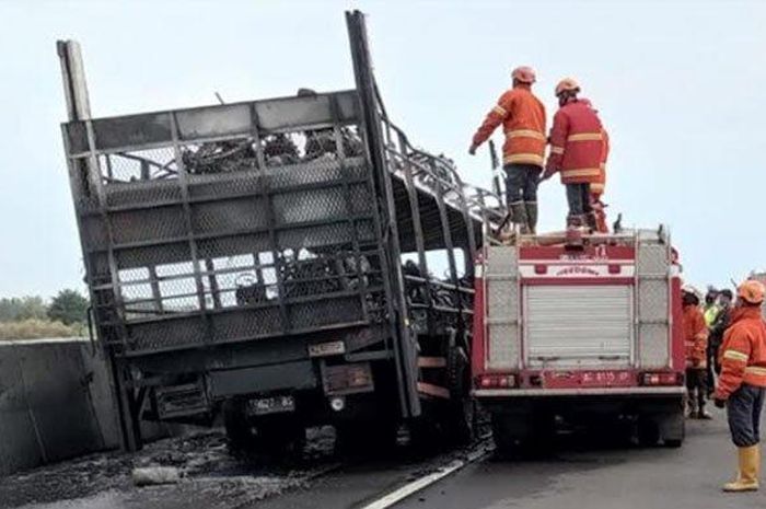 Petugas memadamkan api yang membakar 39 motor di atas truk pengangkut di tol Nganjuk