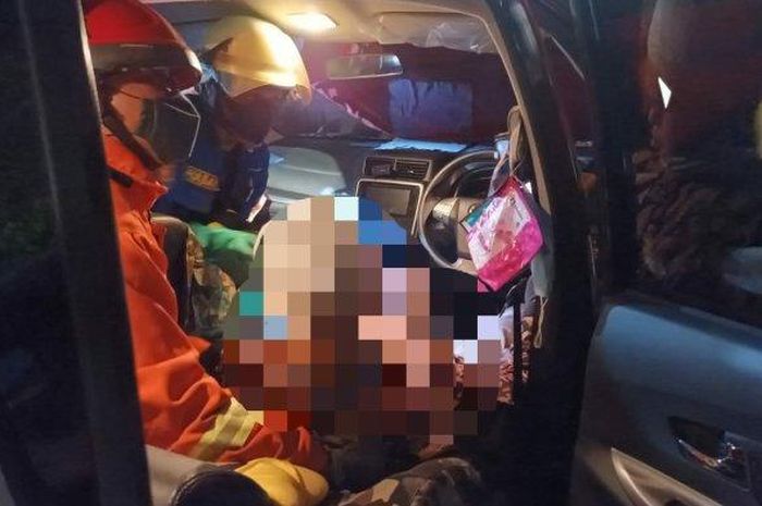 Petugas mengevakuasi pengemudi yang meninggal dalam posisi duduk di bangku Toyota Avanza di Jalan Inspeksi Kalimalang, Jatinegara, Jakarta Timur