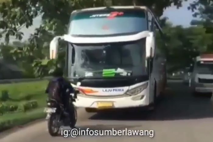 tangkapan layar video yang menampilkan pengendara sepeda motor dengan beraninya mengadang bus Laju Prima yang melawan arah di Sragen, Jawa Tengah