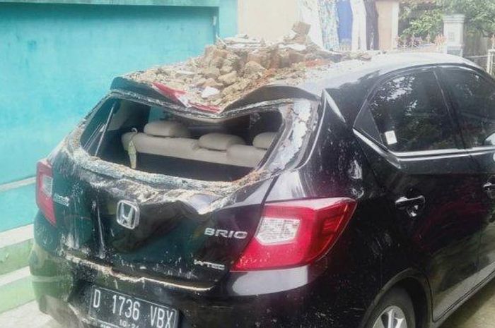 Atap Honda Brio cekung tertimpa puing tembok rumah tetangga yang ambruk di Indihiang, kota Tasikmalaya, Jawa Barat