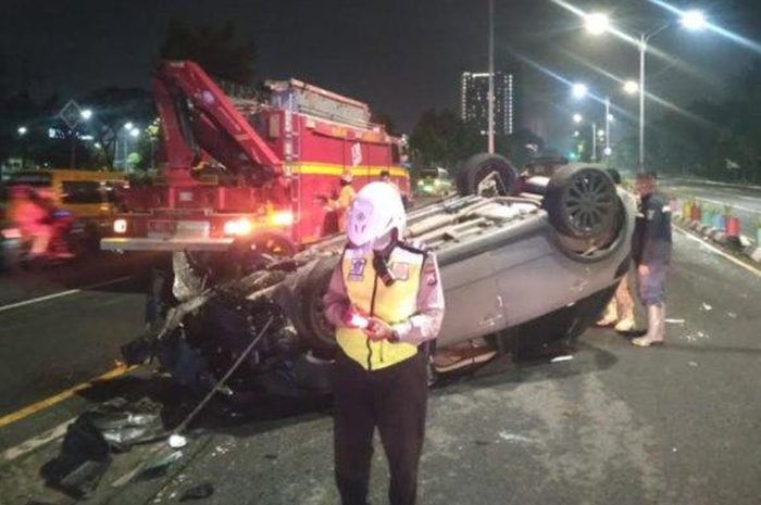 Suzuki SX4 X-Over terbalik di Jl Ahmad Yani, Surabaya, Jawa Timur setelah tabrak tiang