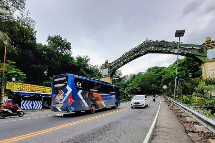 Bus wisata melintas memasuki gapura batas Kabupaten Gunungkidul di Hargodumilah, Patuk. Rekayasa lalu lintas disiapkan guna mengurai kemacetan saat libur Nataru nanti.