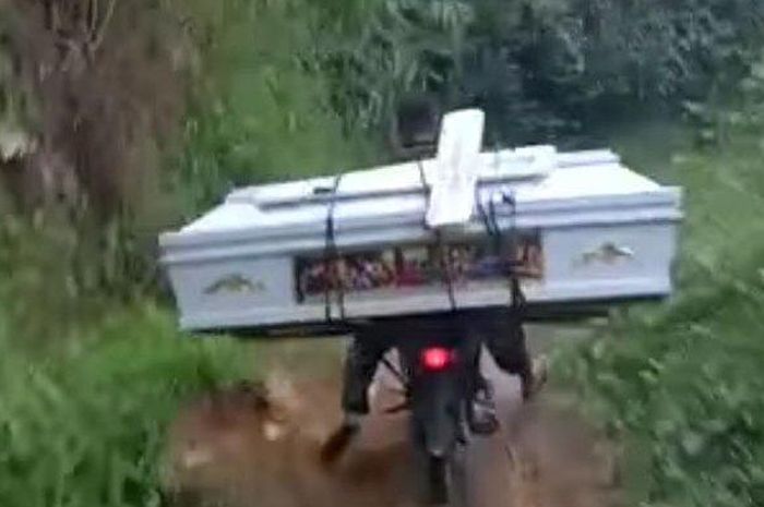 Tangkapan layar video warga mengangkat peti mati dengan sepeda motor melintasi jalan rusak di Dolok Panribuan, Kabupaten Simalungun  