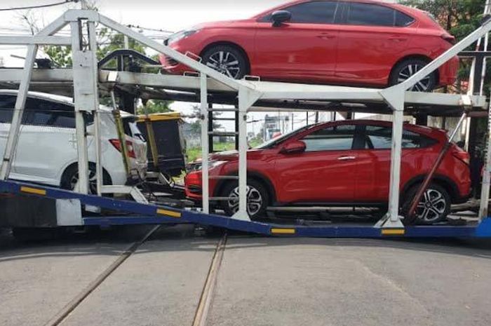 Truk pengangkut mobil baru Honda City Hatchback RS, Brio, HR-V dkk nyakut di atas rel perlintasan KA Jl Hasanudin, kota Kediri, Jatim