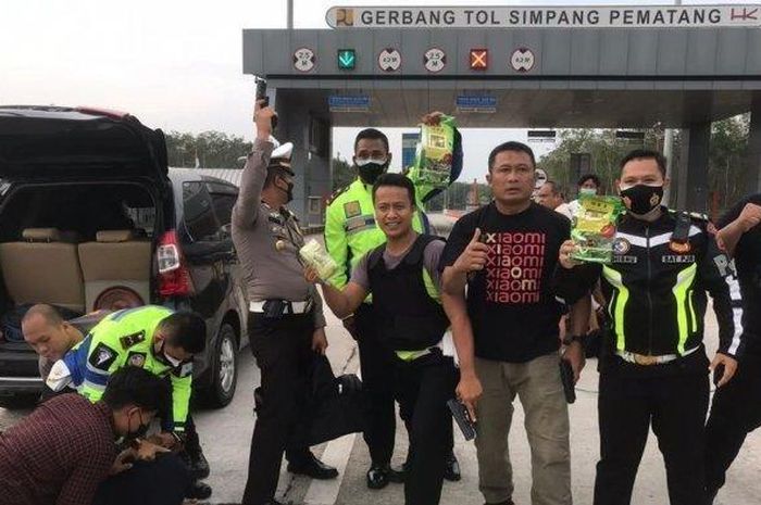 Sejumlah anggota Polisi girang usai menyergap Toyota Avanza hitam di gerbang tol Simpang Pematang, Mesuji, Lampung