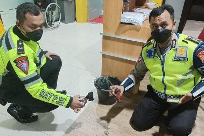 Anggota Polisi Lalu Lintas menunjukan barang bukti bom molotov yang dilempar ke pos lantas kolong tol Jatiwarna, Bekasi, Jawa Barat 