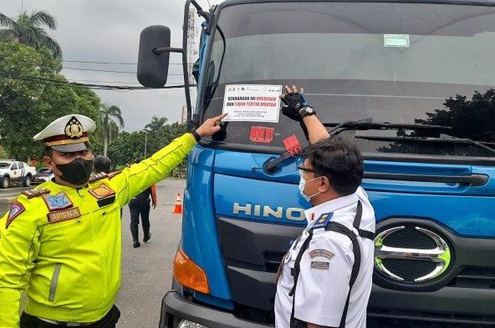 Sejumlah petugas memasangkan stiker kepada para pengendara yang Over Dimensi dan Overloading (ODOL)  