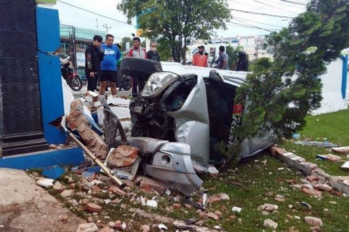 Toyota Rush terguling setelah menghajar tembok pagar kantor BMKG kota Tegal, Jawa Tengah