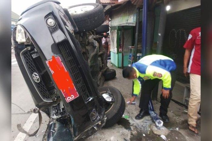 Polisi olah TKP usai Toyota Rush pelat merah milik Kemendagri terguling di Caringin, kabupaten Bogor