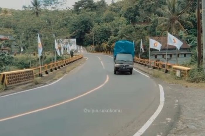 Suzuki Carry pikap bawa barang secara over load lagi ngebut di jalan.