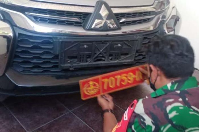 Anggota TNI mencopot pelat nomor milik Garnisun yang dipakai Mitsubishi Pajero Sport milik pengacara di Lamongan, Jawa Timur